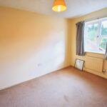 Double bedroom with grey curtains and brown carpet