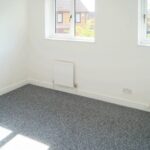 Empty bedroom with two windows in rental house