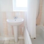 Bathroom of rental property with light pink walls