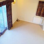 Living room with red patterned curtains and beige carpet