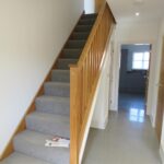 Downstairs hallway with wooden stairs and doors in Milton Keynes rental property