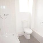 Bathroom with grey flooring and white tile in house to rent Milton Keynes