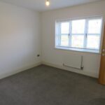 Bedroom with grey carpet and wooden doors