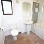 Bathroom with window and shower over bath in flat to rent