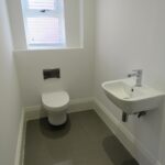 Small cloakroom bathroom with grey floors in rental home