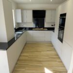 Modern kitchen with black countertops and white cupboards