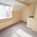 Bedroom with natural sunlight and grey carpet