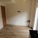 Kitchen diner with brown wooden doors and patio doors leading to garden