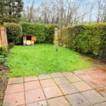 Back garden with tiled patio and children's play house