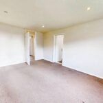 Unfurnished living/dining room with brown carpet in rental property