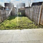 Sunny back garden with patio and wooden fence