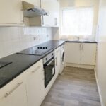 Black and cream coloured kitchen with electric hob in property to rent Milton Keynes