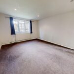 Living room with brown carpet and curtains in rental property