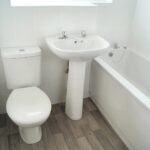 Small white bathroom with bathtub in Milton Keynes rental property