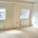 Unfurnished room with two windows and sloping walls in flat to rent