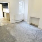 Home to rent near Milton Keynes with grey carpet and archway leading to kitchen