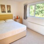 Furnished bedroom with beige furniture and carpet in three bed property to rent