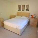 Bedroom with matching wooden furniture in MK rental property