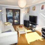 Living room with wooden floors and cream sofa in property for rent Milton Keynes