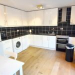 Black and white kitchen and diner with wooden floors in rental property Milton Keynes