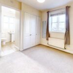 Unfurnished master bedroom with built-in storage and ensuite bathrooom in property to rent in Milton Keynes