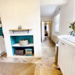 White and teal kitchen with white goods in cottage for rent in Milton Keynes